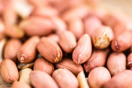 Portion of Peanut Seeds on rustic background (selective focus; close-up shot)