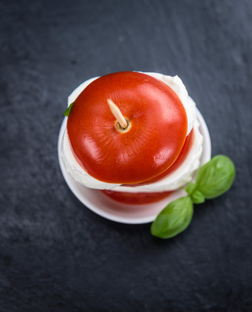 Portion of Mozzarella with Tomatoes (detailed close-up shot; selective focus)の写真素材