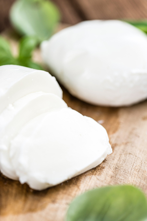 Portion of fresh Mozzarella (close-up shot) on wooden background (selective focus)の写真素材