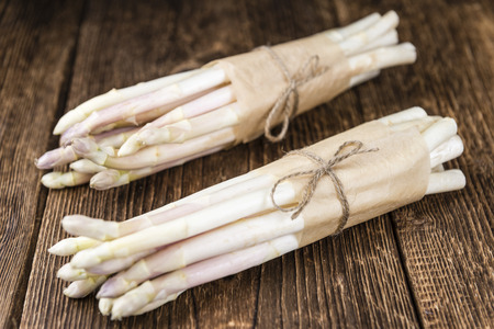 Portion of fresh white Asparagus as detailed close-up shot on wooden background (selective focus)の写真素材