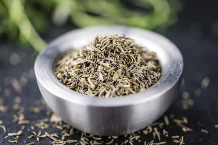 Portion of dried Thyme (close-up shot; selective focus) on rustic background