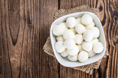 Mozzarella (on wooden background; selective focus) as close-up shotの写真素材