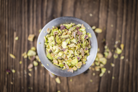 Pistachio Kernels (minced; close-up shot; selective focus) on vintage backgroundの写真素材
