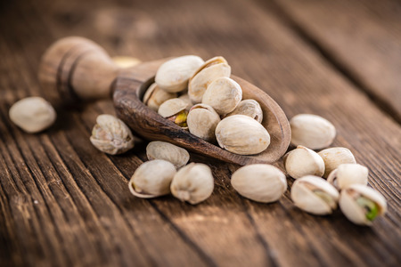 Some whole Pistachios (selective focus; close-up shot) on wooden backgroundの写真素材