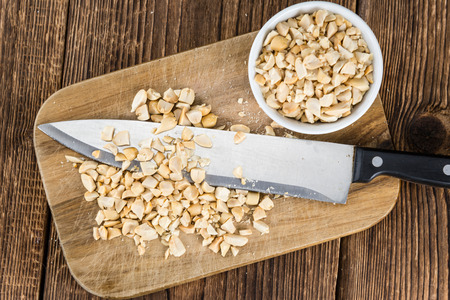 Portion of chopped Peanuts (close-up shot; selective focus) on wooden backgroundの写真素材