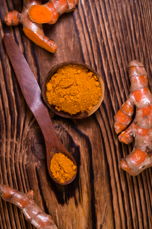 An old wooden table with Turmeric (selective focus, close-up shot)の写真素材