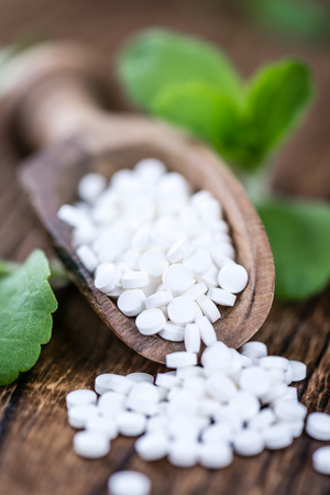 Wooden table with Stevia sweetener pills (selective focus; close-up shot)の写真素材