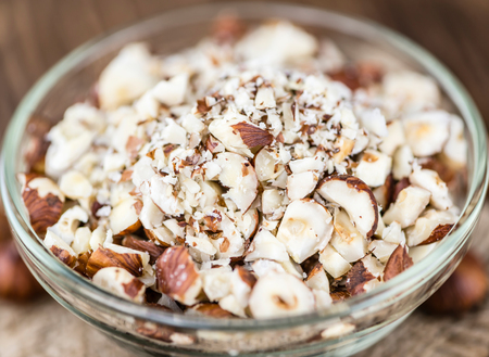 Hazelnuts (chopped, selective focus) on vintage background (close-up shot)の写真素材