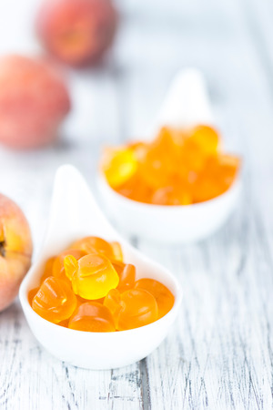 Gummy Peaches (detailed close-up shot) on an old wooden tableの写真素材