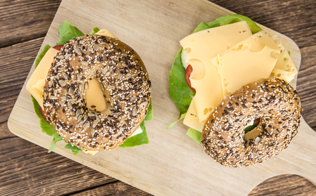 Breakfast Bagel (with cheese; selective focus) on an old wooden tableの写真素材