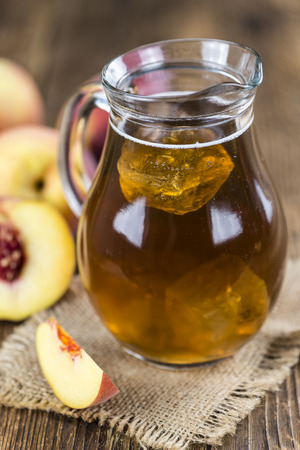 Peach ice tea (selective focus) on an old wooden table (close-up shot)の写真素材