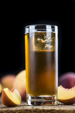 Peach ice tea (selective focus) on an old wooden table (close-up shot)の写真素材