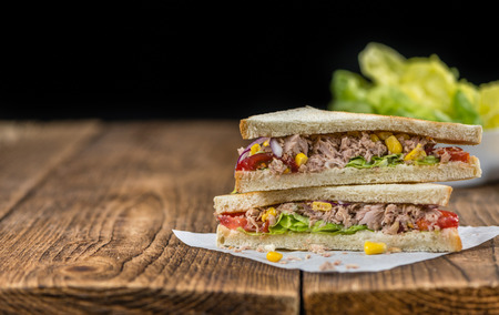 Wooden table with a fresh made Tuna Sandwich (selective focus; close-up shot)の写真素材