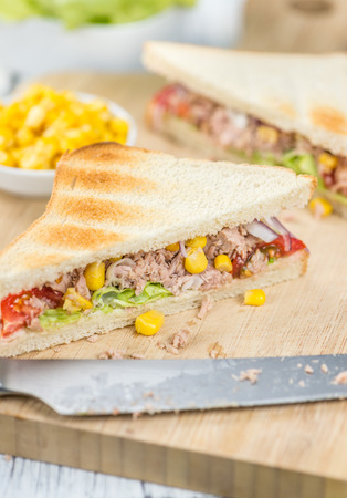 Wooden table with a fresh made Tuna Sandwich (selective focus; close-up shot)の写真素材