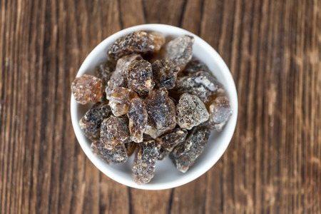 Brown Rock Candy on wooden background (selective focus; close-up shot)