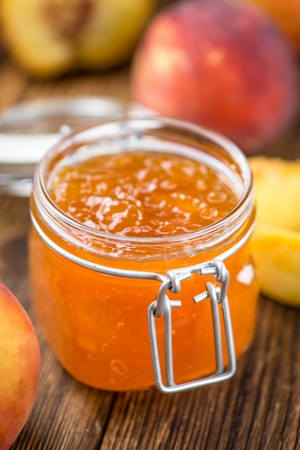 Portion of Peach Jam (close-up shot) on an old wooden tableの写真素材
