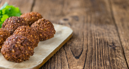 Portion of Falafel on an old wooden table (close-up shot; selective focus)の写真素材
