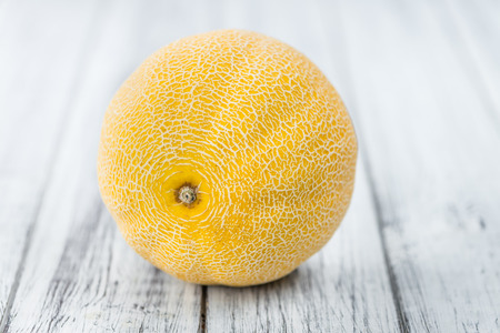 Honeydew Melon on an old wooden table as detailed close-up shot (selective focus)の写真素材