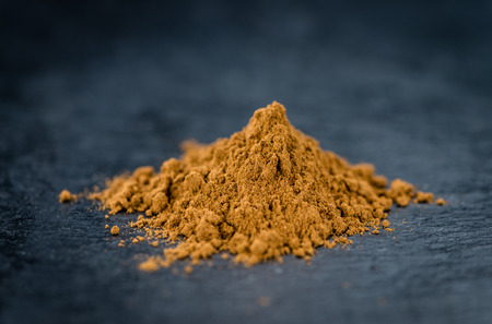 Fresh made Cinnamon Powder on a vintage background (close-up shot)