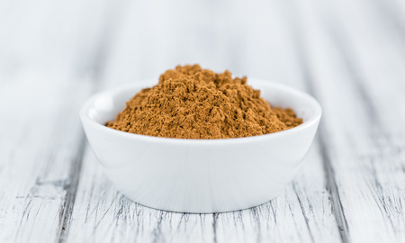 Cinnamon (ground) on an old wooden table as detailed close-up shot (selective focus)