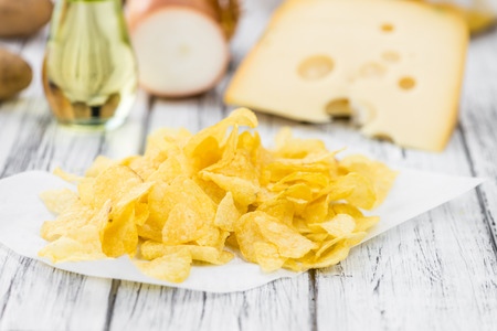 Cheese and Onion Potato Chips on a vintage background as detailed close-up shot (selective focus)の写真素材
