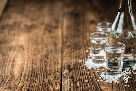 Glass with Sake (selective focus) on an old wooden tableの写真素材