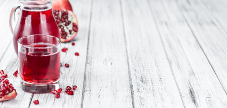 Fresh made Pomegranate juice on a vintage background (close-up shot)の写真素材