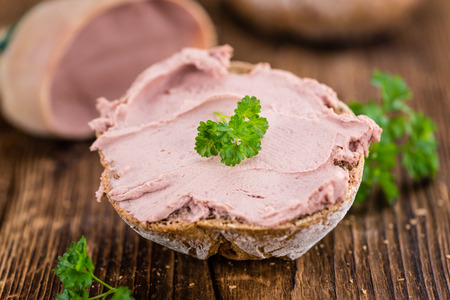 Roll with Liverwurst (German cuisine) on an old wooden table as detailed close-up shot (selective focus)の写真素材