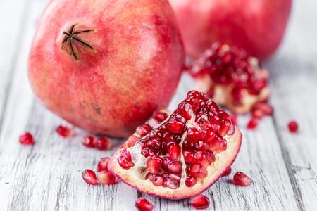 Pomegranate on an old wooden table as detailed close-up shot (selective focus)の写真素材
