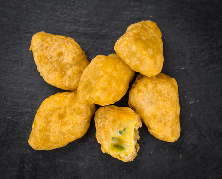 Portion of Cheese Nuggets (with Chilis) as detailed close up shot on a slate slab (selective focus)の写真素材