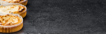 Some fresh Cheesecake on a vintage slate slab (selective focus; close-up shot)の写真素材