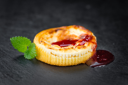 Cheesecake with Sauce on a vintage slate slab (close-up shot; selective focus)の写真素材