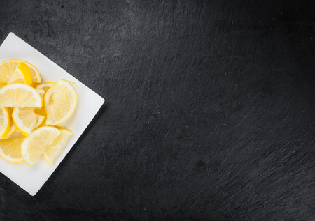 Some fresh Lemon Slices on a vintage slate slab (selective focus; close-up shot)の写真素材