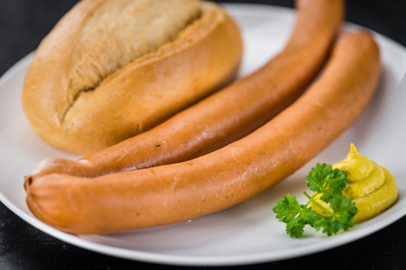 Sausages (Frankfurter) on a vintage slate slab (close-up shot; selective focus)の写真素材