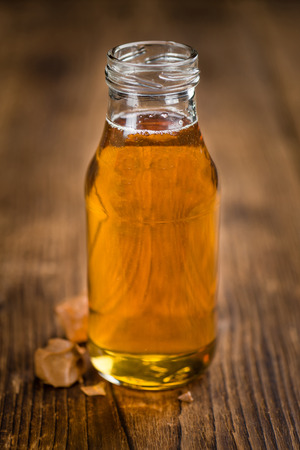 Syrup (Caramel taste) on an old wooden table as detailed close-up shot (selective focus)の写真素材