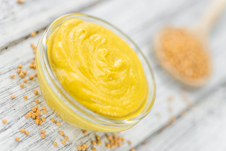 Portion of homemade Mustard on wooden background (selective focus; close-up shot)の写真素材