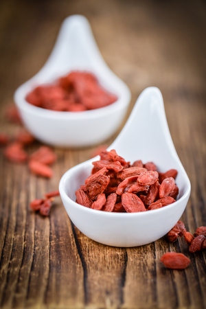 Goji Berries (dried) on an old wooden table as detailed close-up shot (selective focus)の写真素材