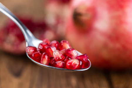 Pomegranate on an old wooden table as detailed close-up shot (selective focus)
の写真素材