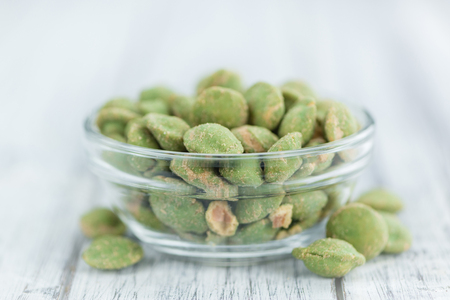 Peanuts (with Wasabi flavor) on an old wooden table as detailed close-up shot (selective focus)の写真素材