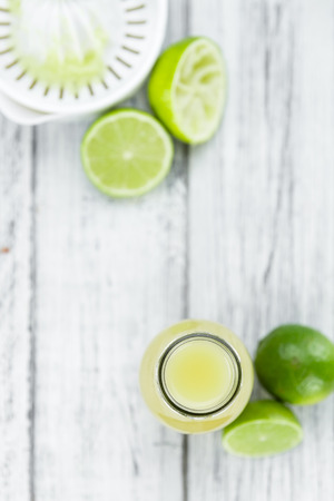 Fresh Lime Juice as high detailed close-up shot on a vintage wooden table (selective focus)の写真素材