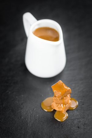 Caramel Sauce on a vintage slate slab (close-up shot; selective focus)の写真素材