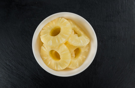 Some fresh Preserved Pineapple Rings on a vintage slate slab, selective focus, close-up shotの写真素材