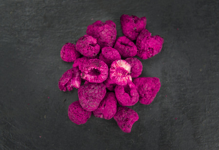 Dried Raspberries on a vintage slate slab as detailed close-up shot; selective focus