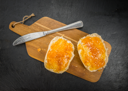 Portion of Peach Jam on a rustic slate slab, selective focus, close-up shotの写真素材