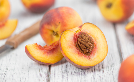 Peaches on an old wooden table as detailed close-up shot; selective focusの写真素材