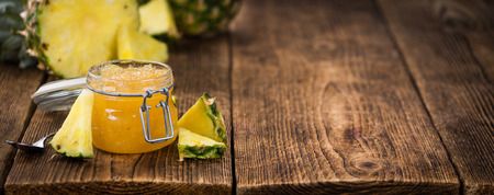 Pineapple Jam as high detailed close-up shot on a vintage wooden table; selective focusの写真素材