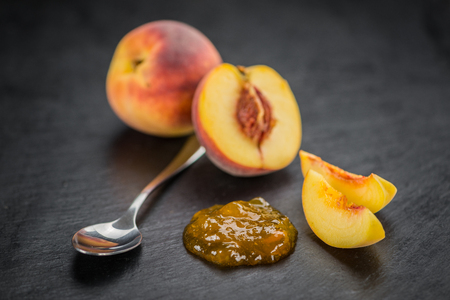 Portion of Peach Jam on a rustic slate slab, selective focus, close-up shotの写真素材