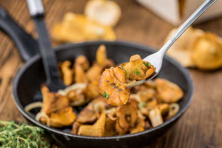 Fried Chanterelles on rustic wooden background as close-up shotの写真素材