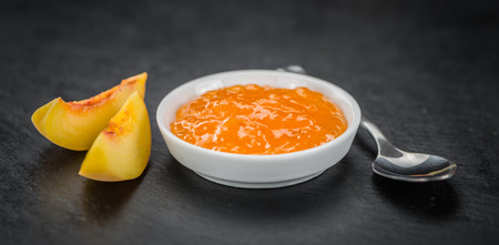 Peach Jam on a vintage slate slab as detailed close-up shot; selective focusの写真素材
