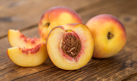 Fresh Peaches as high detailed close-up shot on a vintage wooden table; selective focusの写真素材